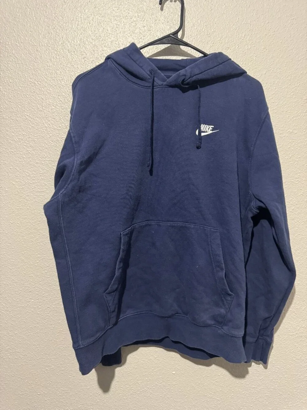 Navy blue Nike pullover hoodie, featuring a white embroidered Nike Logo